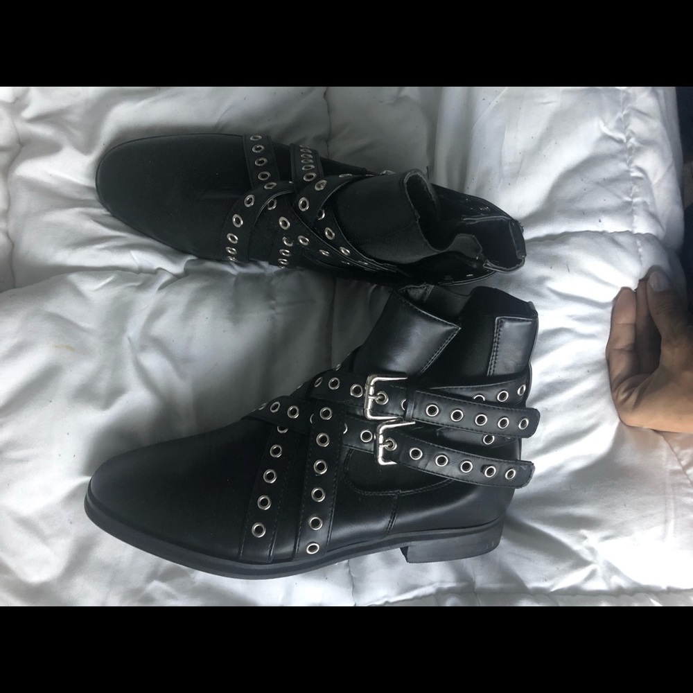 Black combat boots with sliver holes on straps